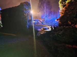 Zdjęcie przedstawia: samochód, który wjechał w ogrodzenie posesji.