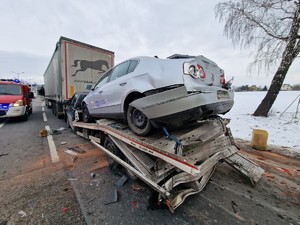 Zdjęcie przedstawia: tył lawety z przewożonym samochodem, widoczne uszkodzenia pojazdów.