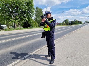 Zdjęcie przedstawia: policjanta podczas pomiaru prędkości.